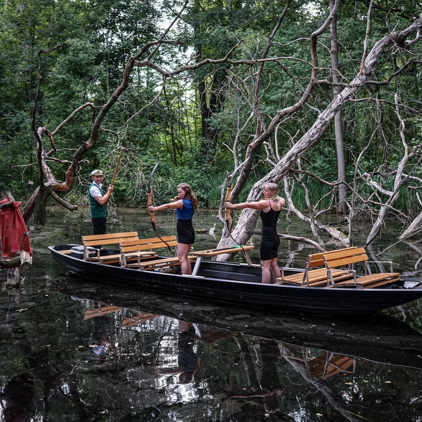 2 Damen und ein Fährmann beim Bogenschiessen vom Kahn Junggesellenabschied Spreewald